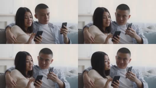 中国夫妇坐在沙发上玩手机高清在线视频素材下载