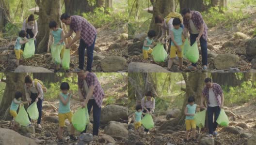 亚洲家庭志愿者在河上捡起一个塑料瓶高清在线视频素材下载