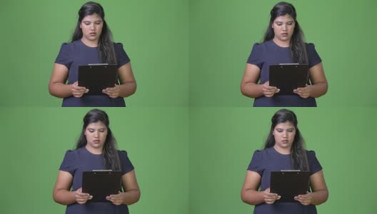 年轻的超重美丽的印度女商人在绿色的背景高清在线视频素材下载