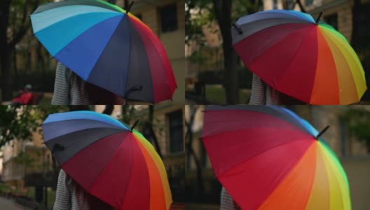 近距离观看一个开放的彩色彩虹伞在女性的手中。Slowmotion拍摄高清在线视频素材下载