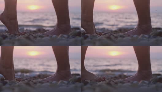 在美丽的日落时分，在海边的沙滩上，一对相爱的情侣在约会时的双腿。缓慢的运动。男人举起了手，举起心爱的女人。3840 x2160高清在线视频素材下载