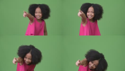 年轻可爱的非洲女孩有非洲式的头发，笑着指着手指高清在线视频素材下载