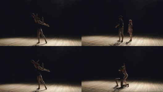 两个芭蕾舞演员在舞台上黑暗中跳舞。高清在线视频素材下载