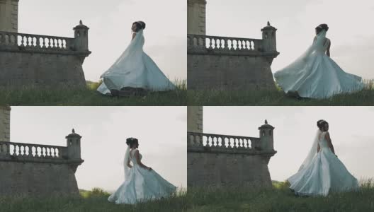美丽可爱的新娘站在古老的城堡附近高清在线视频素材下载