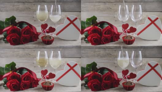 情人节。两杯香槟，红玫瑰，木制背景上的心形盒子。倒香槟。情人节。文本的地方高清在线视频素材下载