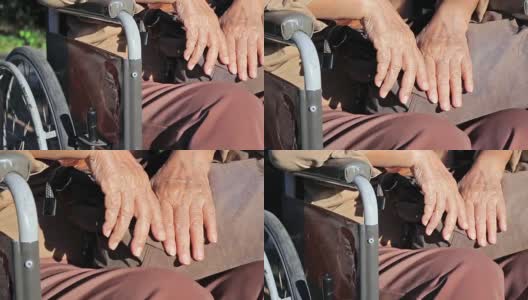 一位老年妇女手放在轮椅上。高清在线视频素材下载