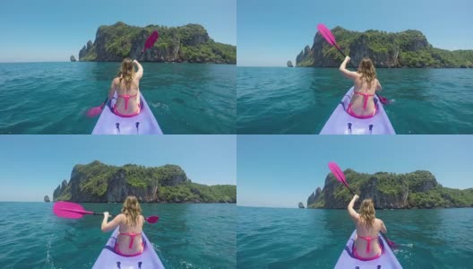 特写:在泰国偏远的岛屿上，一名白种妇女划船向悬崖。高清在线视频素材下载