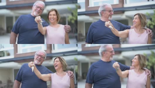 一对成熟的快乐夫妇展示他们的新房子的钥匙高清在线视频素材下载