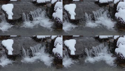 雪在小溪的石头上高清在线视频素材下载