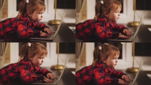 一个小女孩模仿她的妈妈，晚上在家里用电脑工作。高清在线视频素材下载