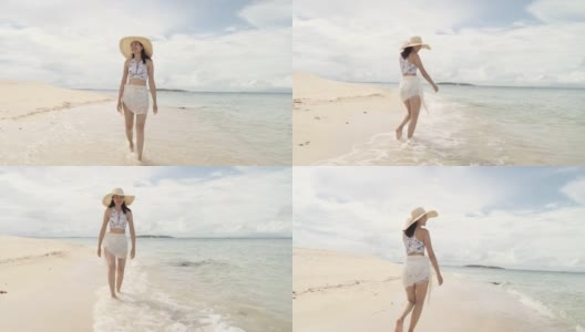 美丽年轻的亚洲女人走在海滩上。高清在线视频素材下载