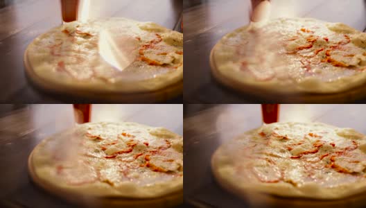 意大利披萨与切片蔬菜，融化的奶酪在前景。把奶酪放在烤披萨上的人。木制盘子上的典型意大利菜。开胃的披萨。Delisious菜高清在线视频素材下载